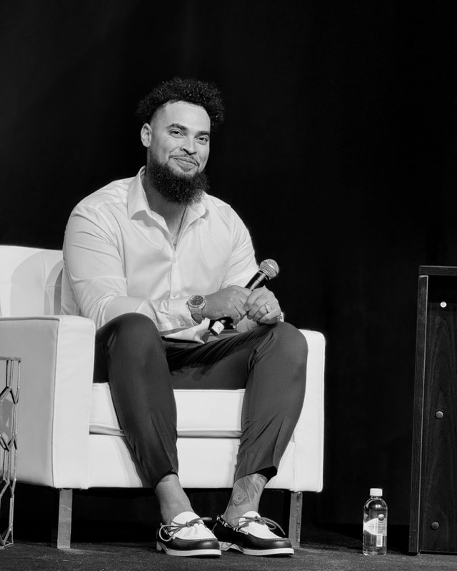 On stage with a mic at a live speaking event
